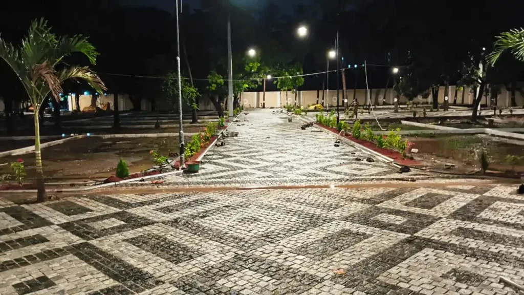 Night view of villa plots with paved roads, street lighting, and landscaped layout
