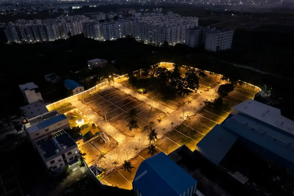 Night view of gated villa plots with paved roads and lighting
